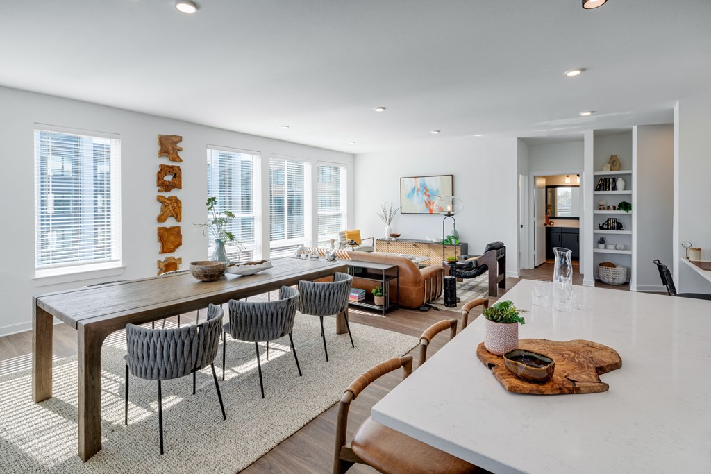 A modern dining room with a wooden table and chairs.