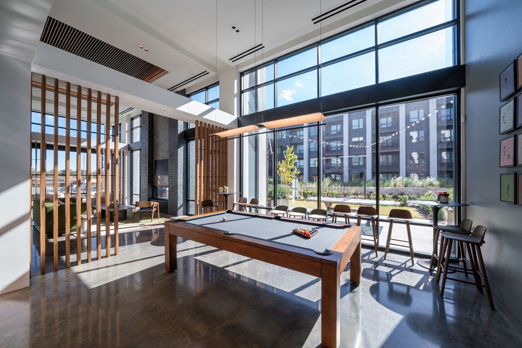A room with a long table and chairs with a view of the city outside the windows.