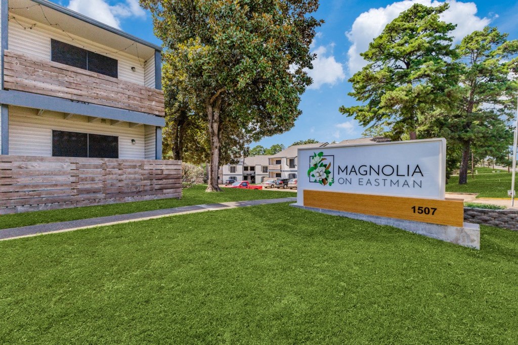 a sign with magnolia on eastman written on it in front of a building