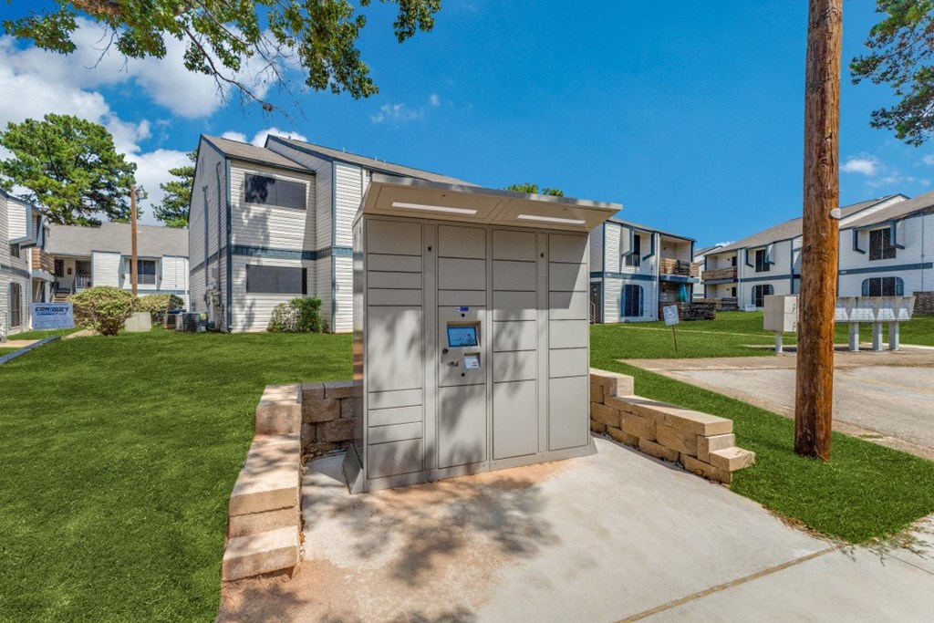 a small parking lot with a parking meter in front of an apartment building