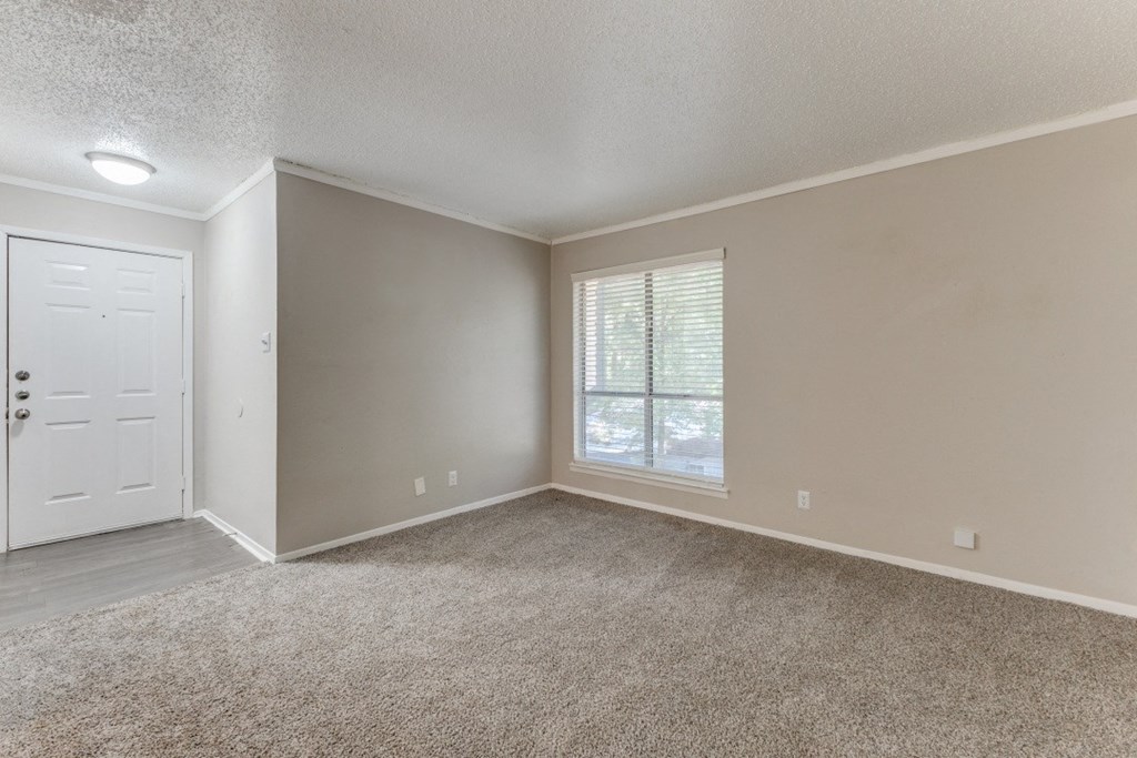 an empty bedroom with a window and a door