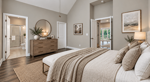 A bedroom with a large bed and a round mirror on the wall.