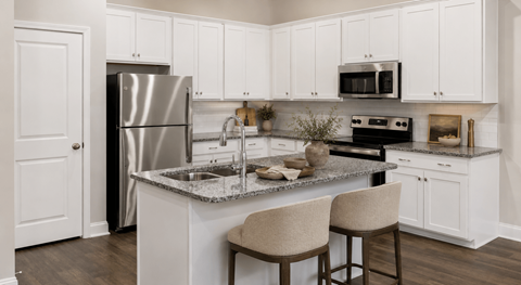 A kitchen with white cabinets and a granite countertop.