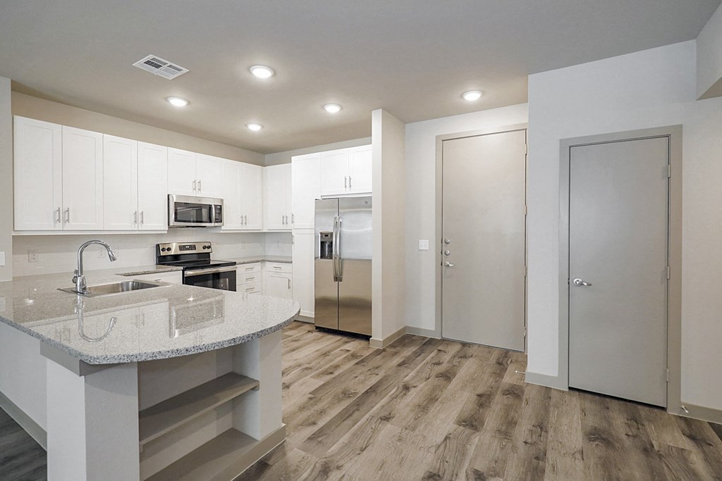 a kitchen with white cabinets and stainless steel appliances