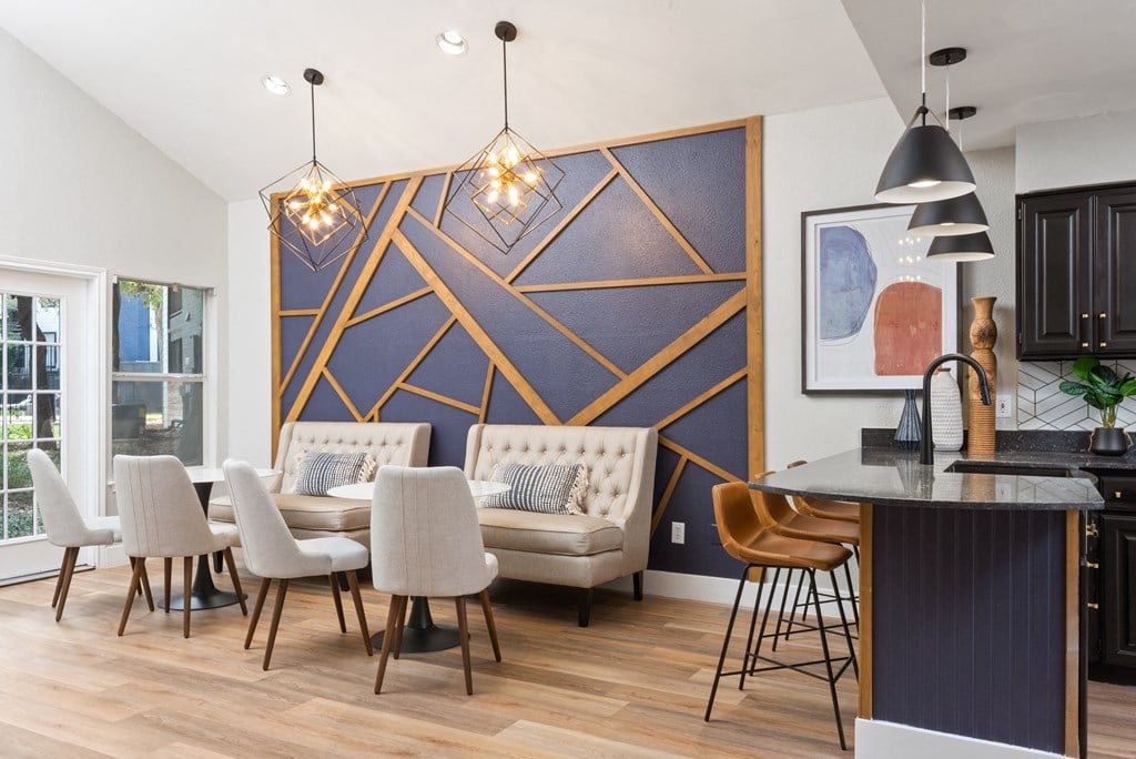 a living room with a dining room table and chairs and a kitchen area with a couch and