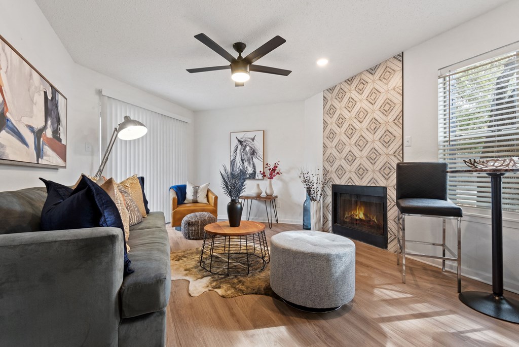 a living room with a fireplace and a ceiling fan