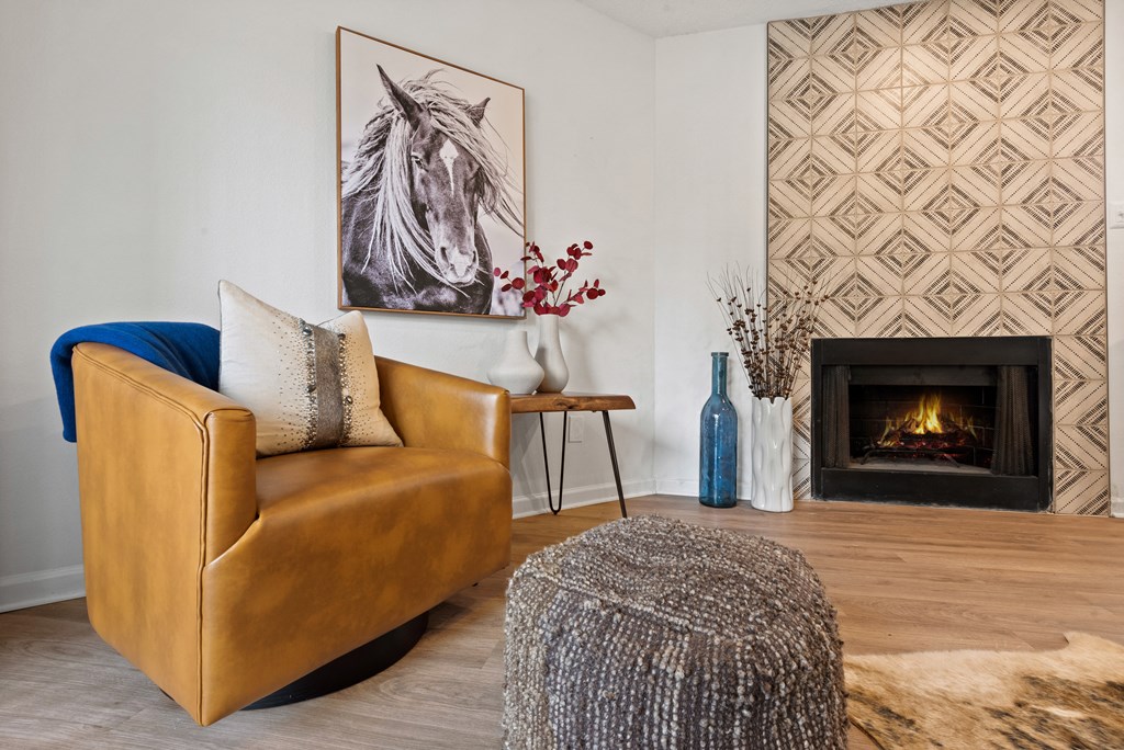 a living room with a leather chair and fireplace