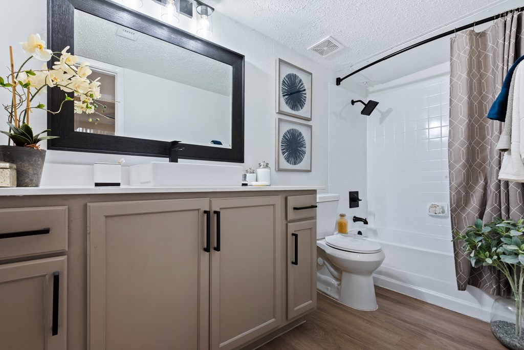 a bathroom with white walls and a wooden floor
