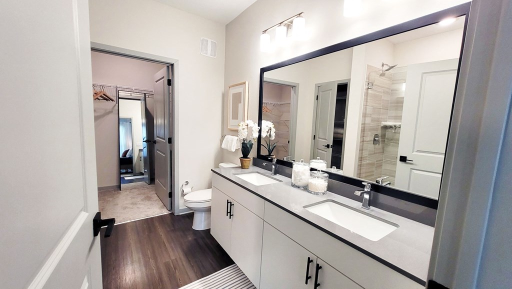 a bathroom with white cabinets and a large mirror