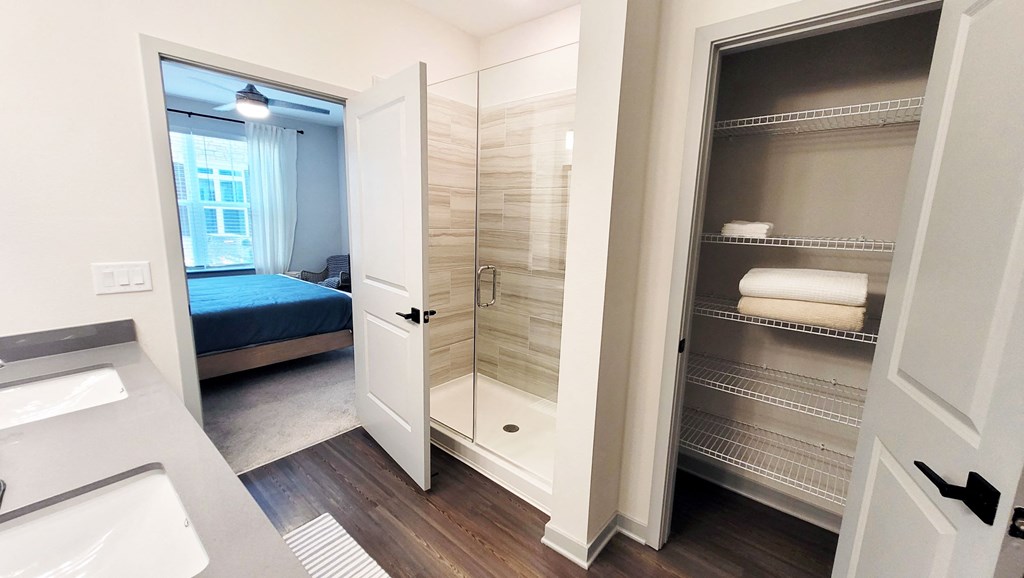 a small bathroom with a shower and a bed in a room