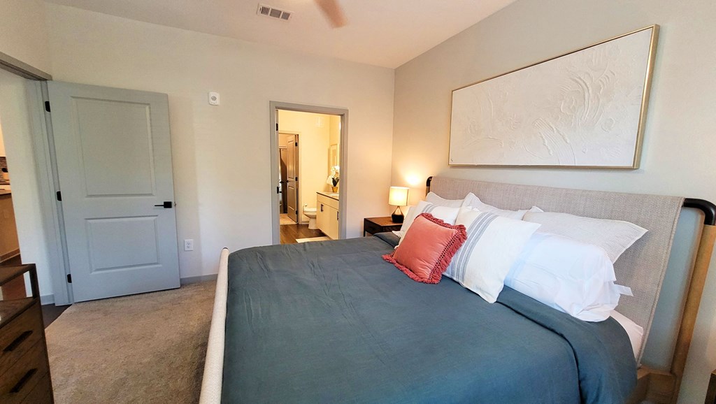 a bedroom with a bed and a door to a bathroom