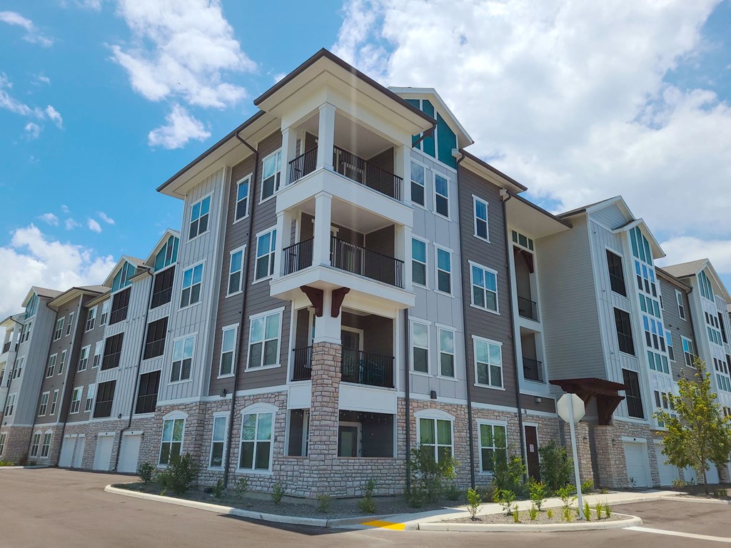 a large apartment building with a blue sky in the background