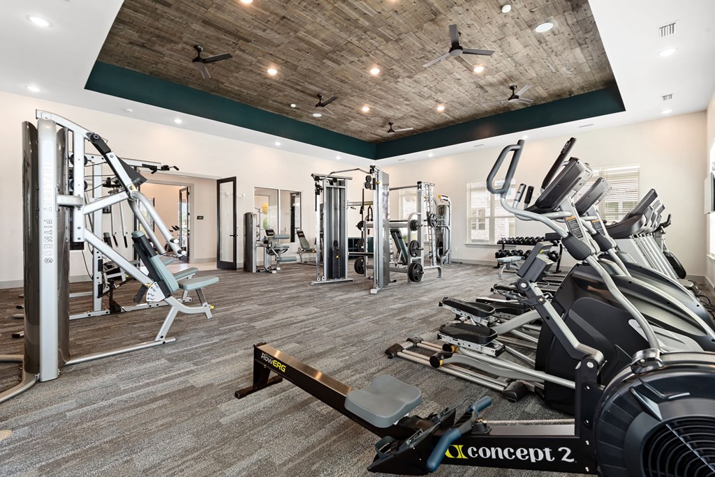 a spacious fitness center with treadmills and other exercise equipment
