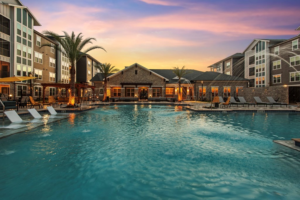 a large swimming pool with a sunset in the background