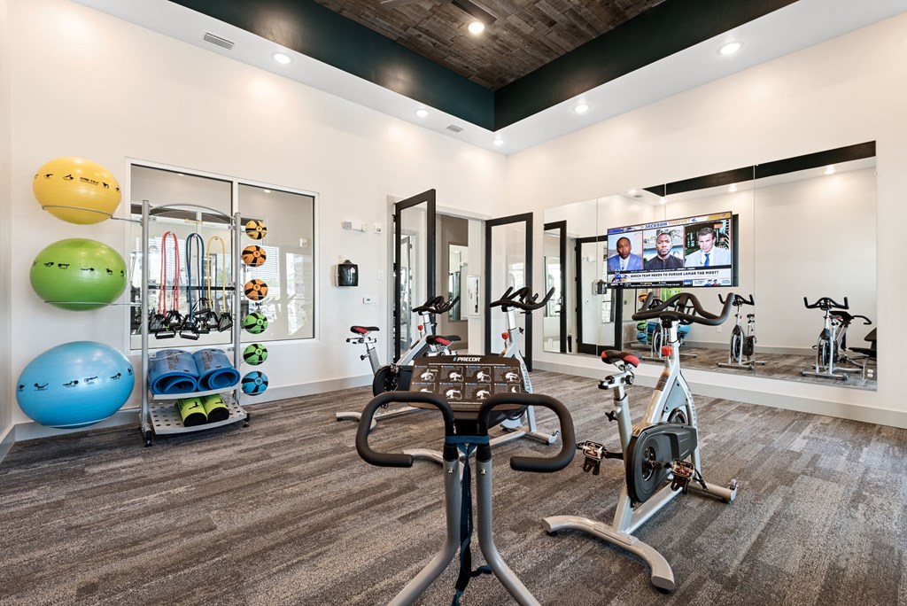 a home gym with exercise equipment and a flat screen tv