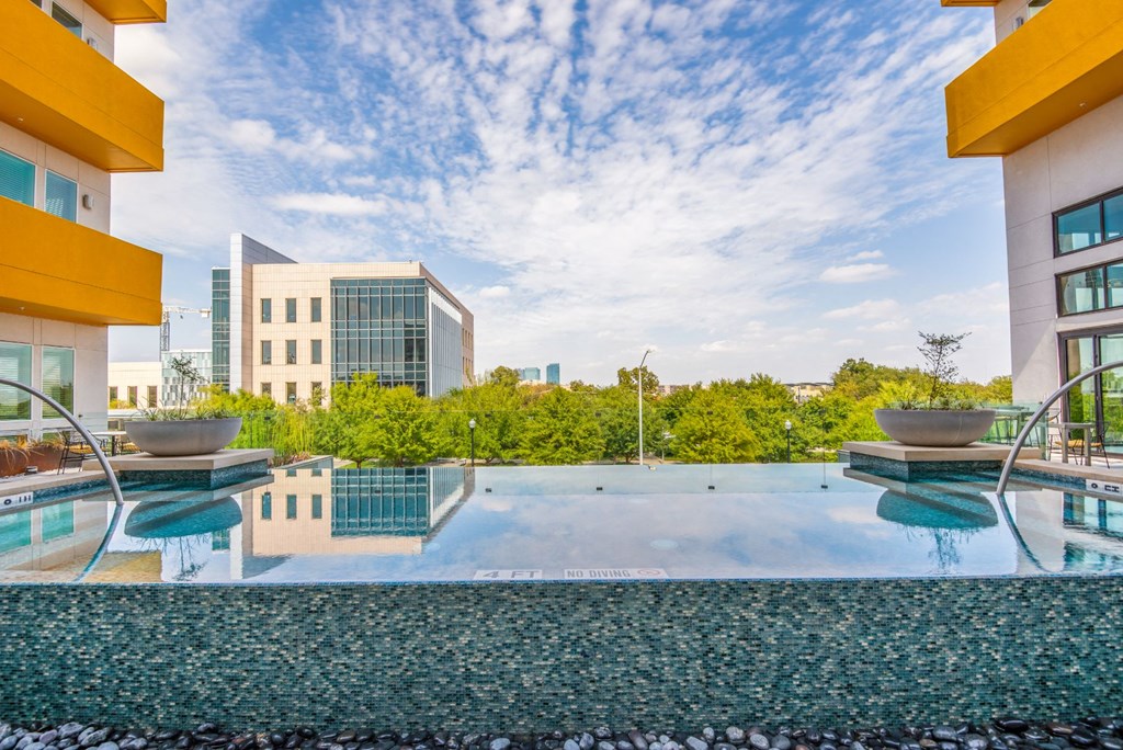 a swimming pool with buildings in the background and a blue sky