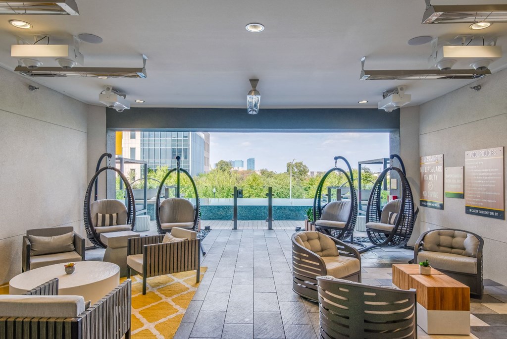 a lobby with chairs and tables and a swimming pool