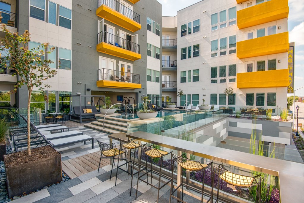 a courtyard with tables and chairs in front of an apartment building
