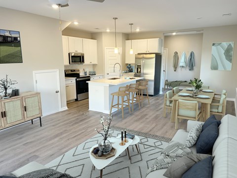 A modern kitchen with a breakfast bar and a dining table with chairs.