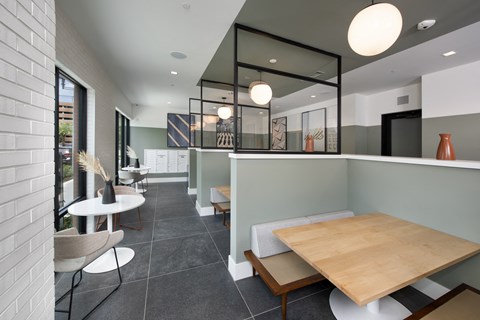 a dining area with a wooden table and chairs and a glass partition