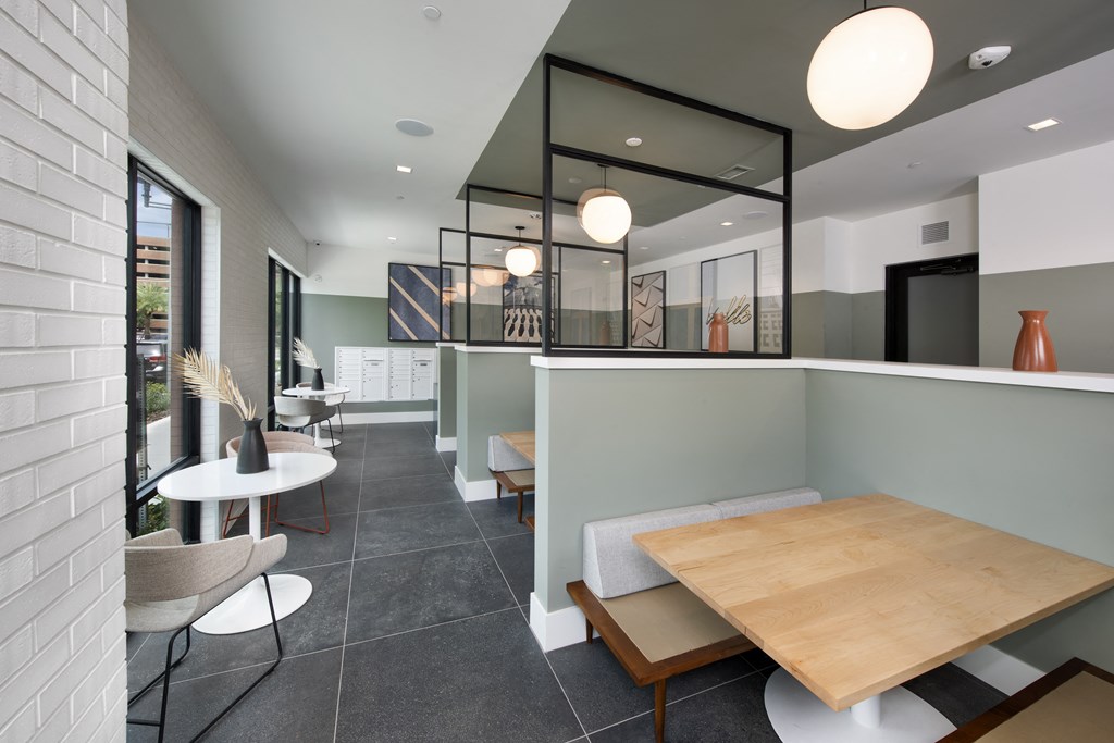 a dining area with a wooden table and chairs and a glass partition