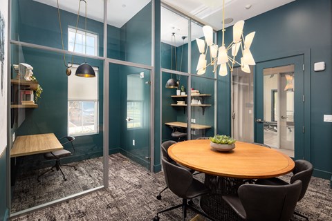 A modern dining room with a round wooden table and chairs.