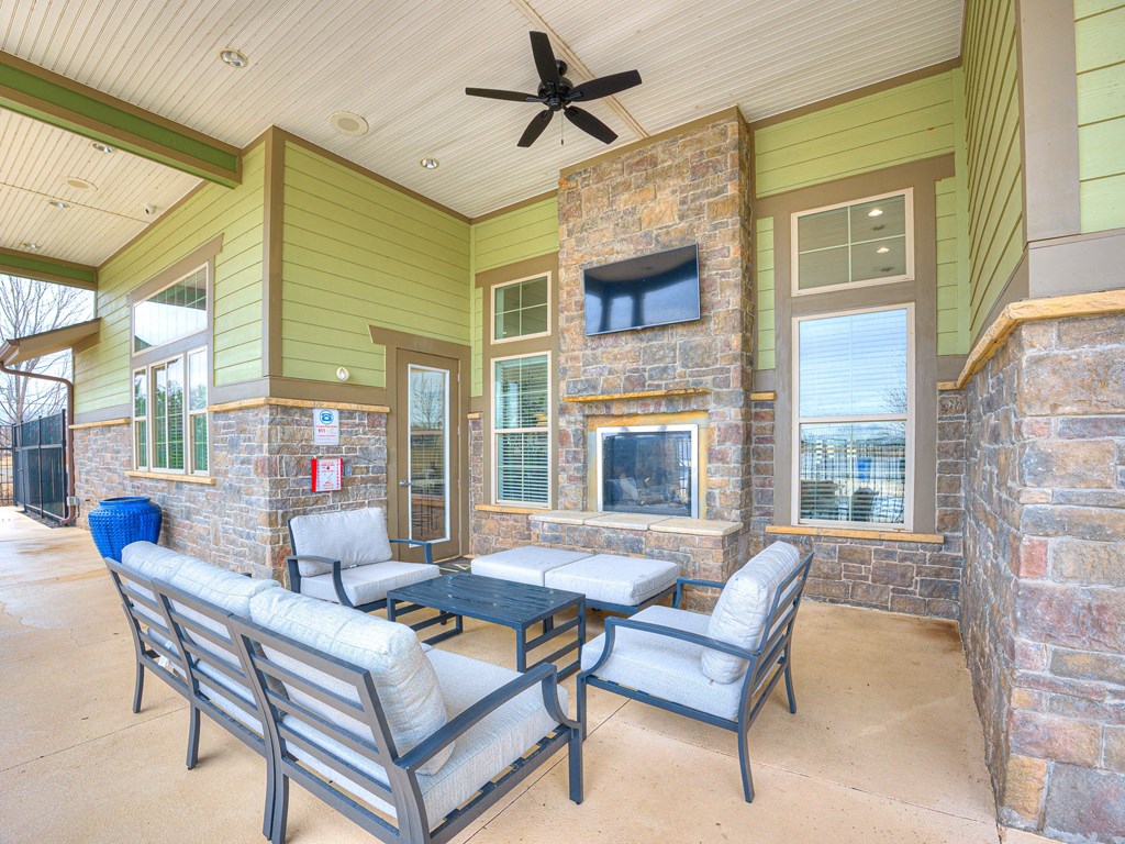 a patio with chairs and a fireplace