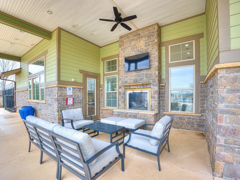 a patio with chairs and a fireplace