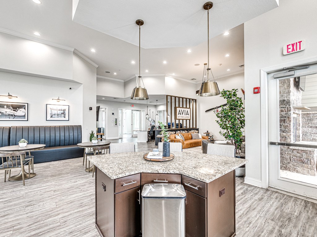 a kitchen with an island and a living room in the background