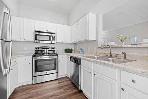 A kitchen with white cabinets and stainless steel appliances.