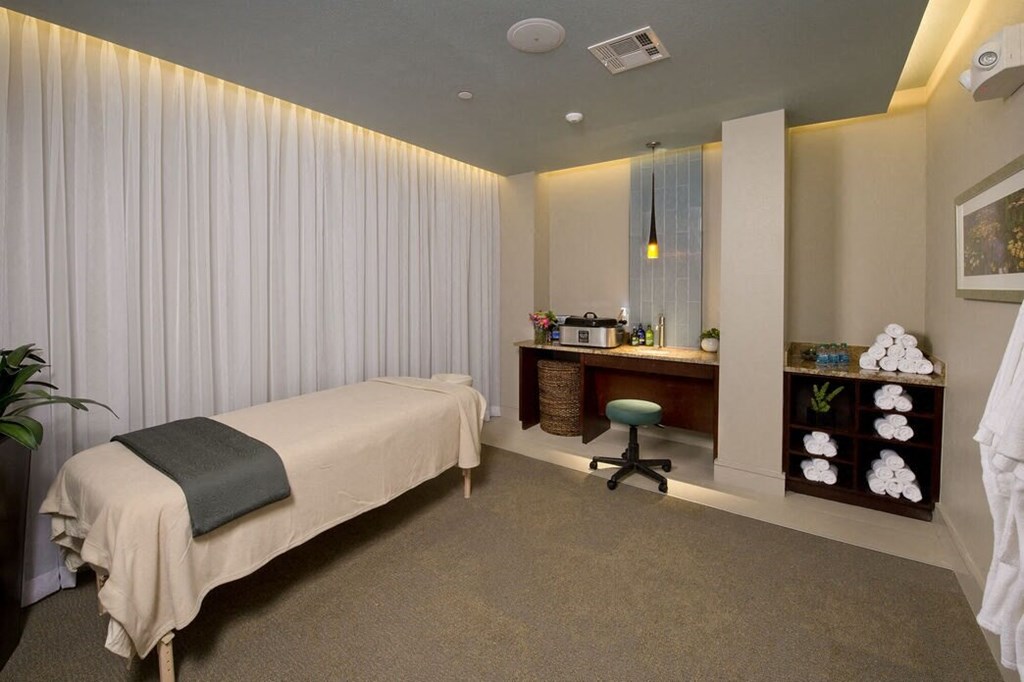 a bedroom with a bed and a desk and a mirror