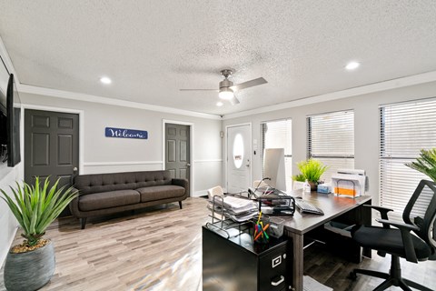 a living room with a desk and a couch