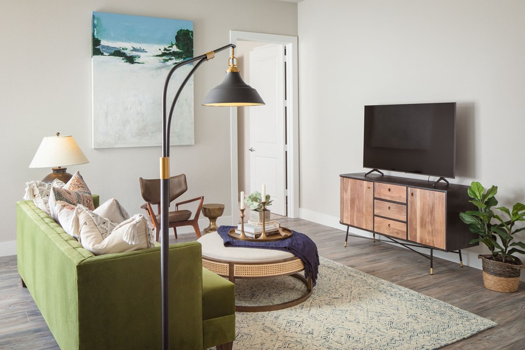 a living room with a green couch and a television