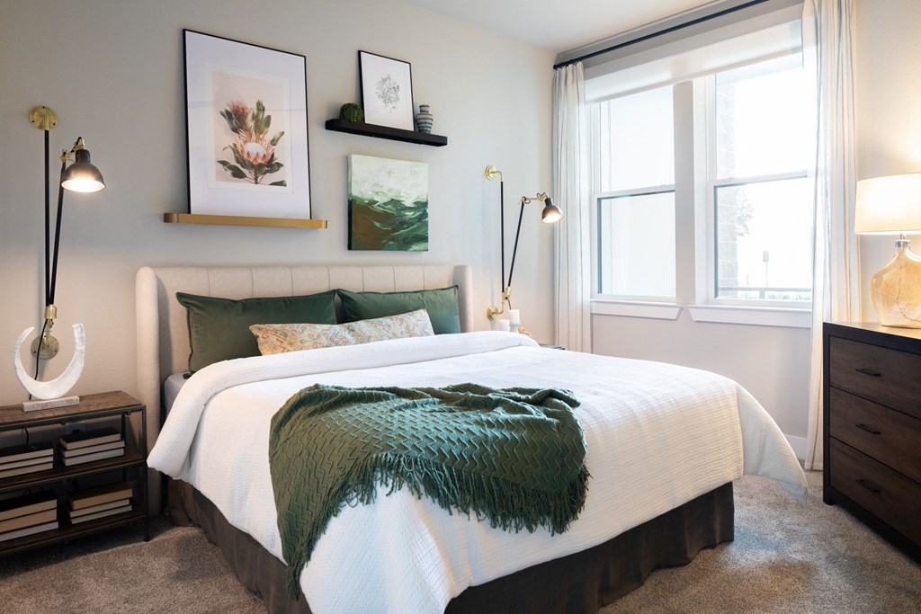 a bedroom with a bed and two windows