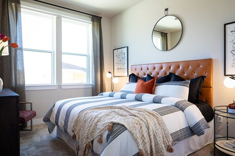 A bedroom with two beds covered in blankets and pillows.