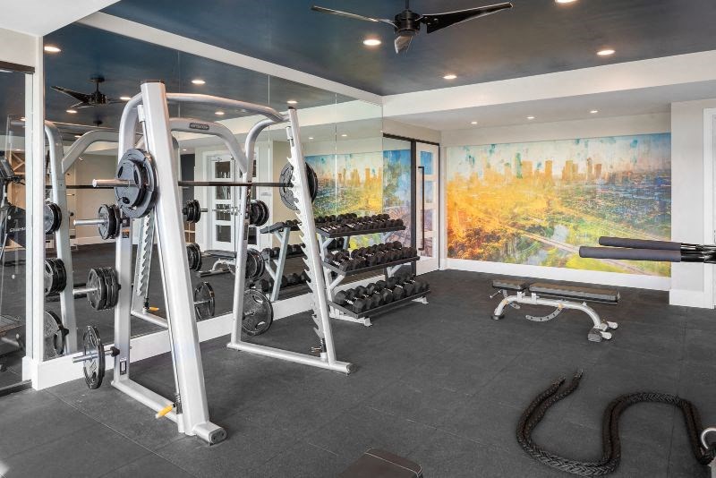 a home gym with weights and a painting on the wall