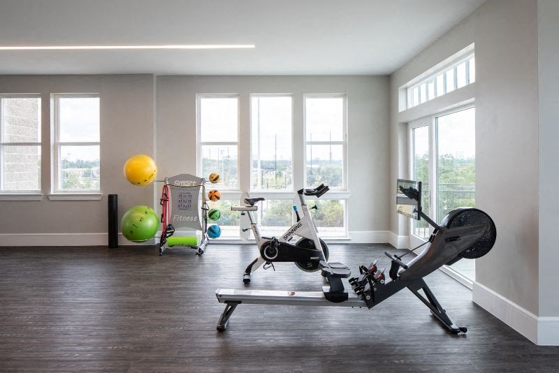 a home gym with exercise equipment and windows