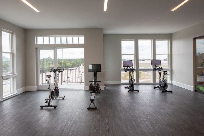 an empty room with exercise equipment and windows