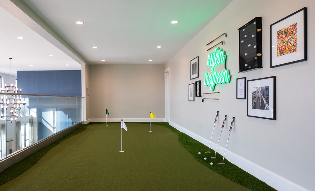 a putting green in a room with golf equipment