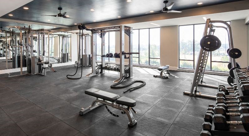 a gym with a lot of equipment and windows