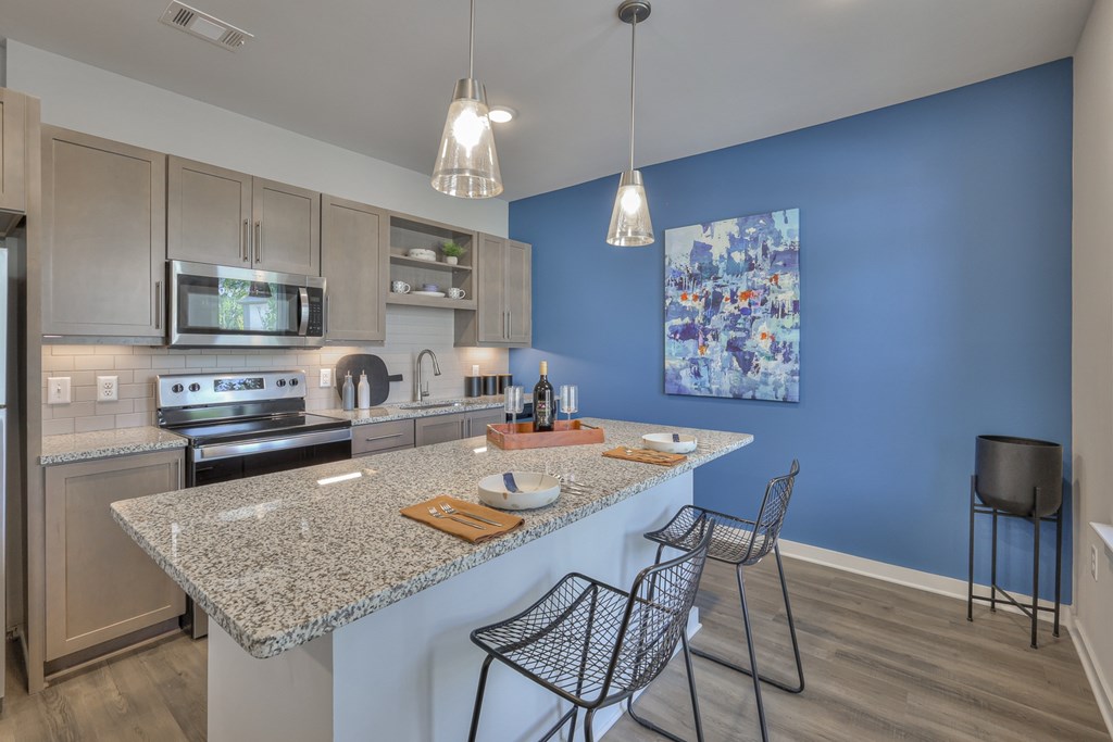 A kitchen with a granite countertop and a blue wall.