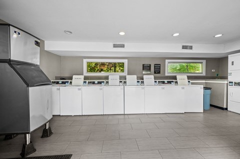 a kitchen with white cabinets and a counter with chairs
