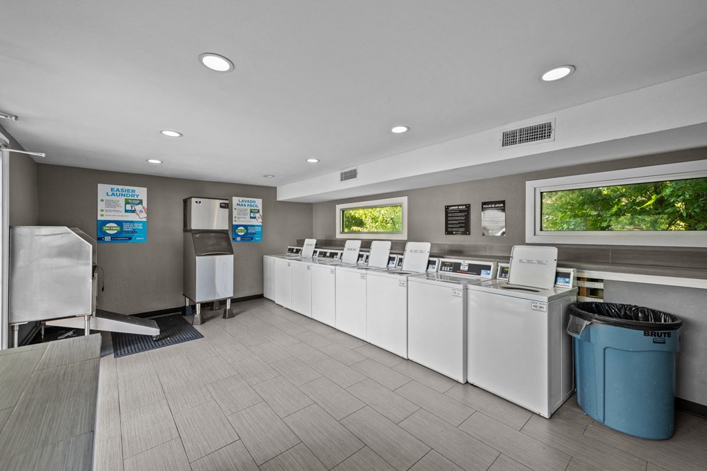 the laundry room is equipped with washers and dryers and a row of machines