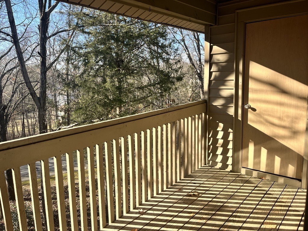 a balcony with a view of trees and a door