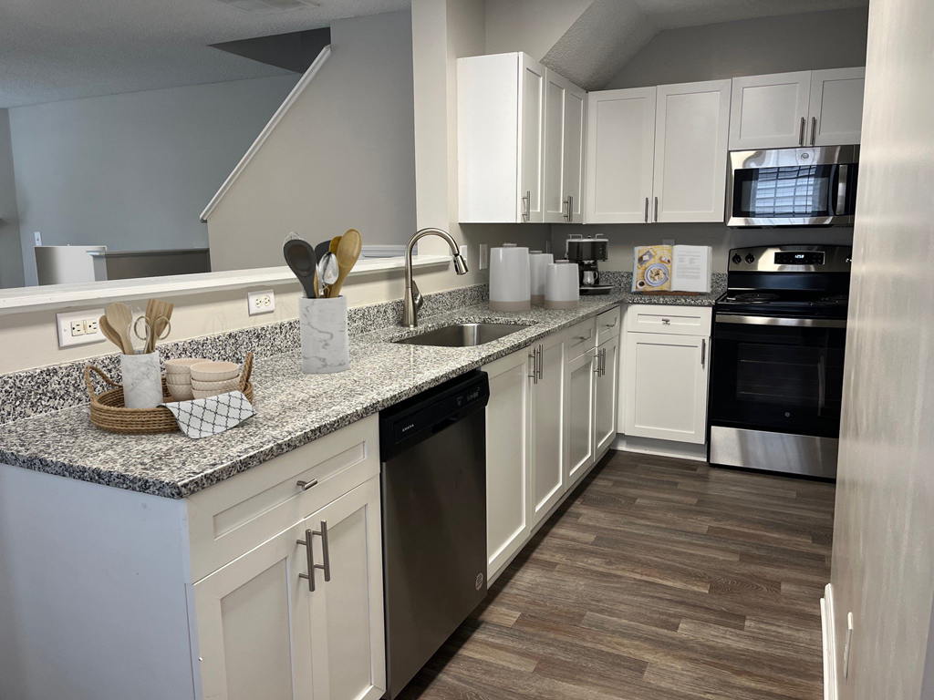 a kitchen with white cabinets and granite counter tops