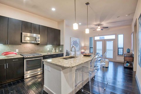 A modern kitchen with dark wood cabinets and stainless steel appliances.