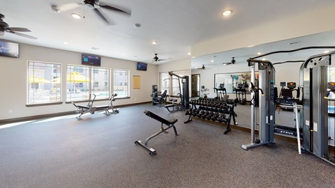 A spacious gym with a variety of equipment including treadmills, weights, and exercise machines.