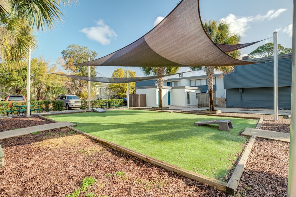 a backyard with a lawn and a shade sail