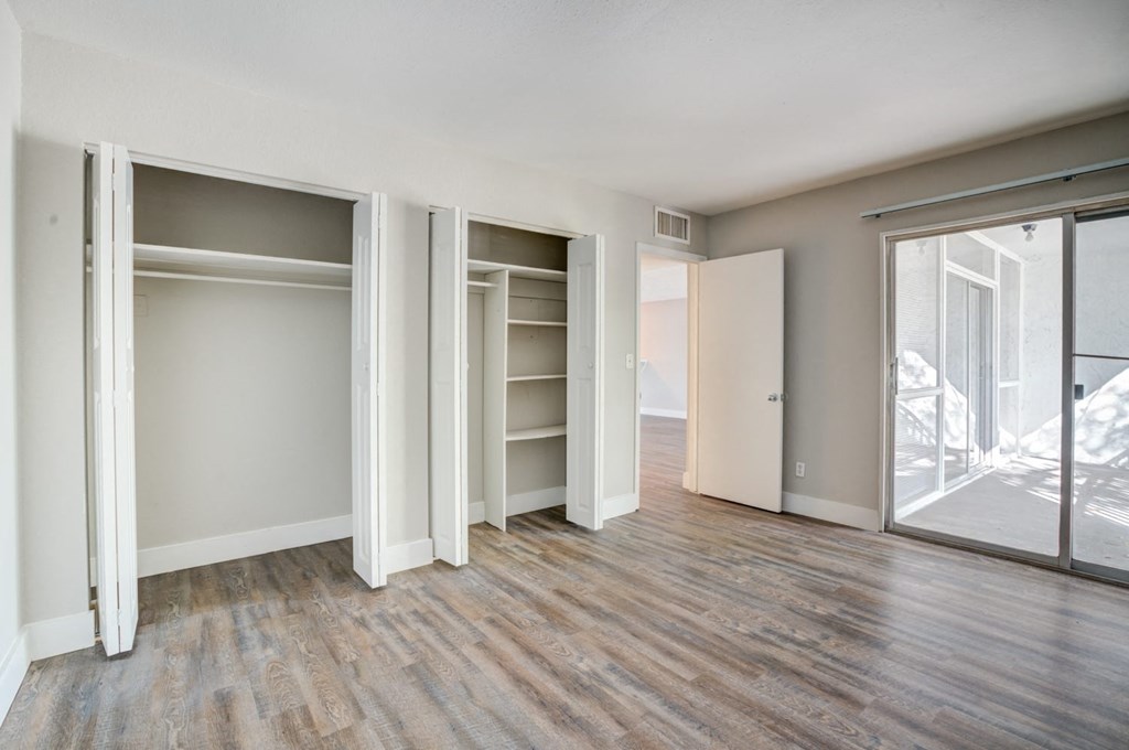 an empty living room with sliding glass doors to a closet