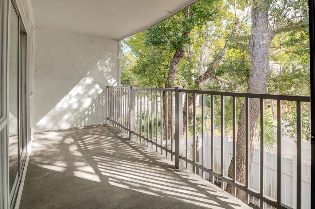 a balcony with a view of a yard and trees